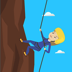 Image showing Woman climbing in mountains with rope.