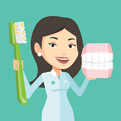 Image showing Dentist with dental jaw model and toothbrush.