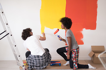 Image showing multiethnic couple painting interior wall