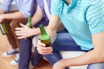 Image showing men with beer bottles sitting on sofa at home