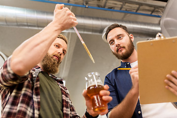 Image showing men with pipette testing craft beer at brewery