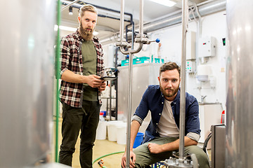 Image showing men with tablet pc at craft beer brewery kettle