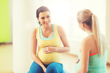 Image showing two happy pregnant women sitting on balls in gym