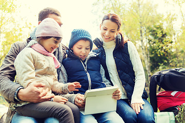 Image showing happy family with tablet pc and backpacks at camp