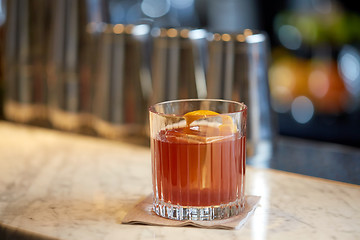 Image showing glass of cocktail with orange peel at bar