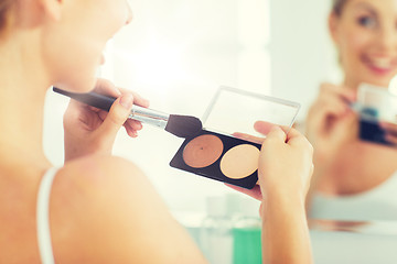 Image showing woman with makeup brush and foundation at bathroom