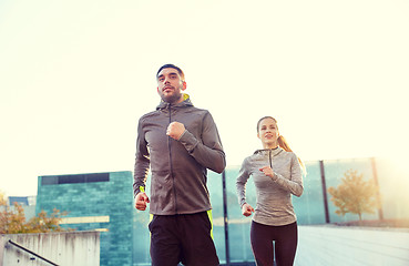 Image showing happy couple running upstairs on city stairs