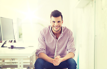 Image showing happy creative man with computer at office