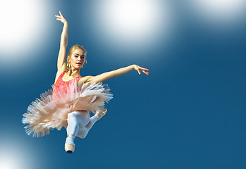 Image showing Beautiful female ballet dancer on a grey background. Ballerina is wearing pink tutu and pointe shoes.