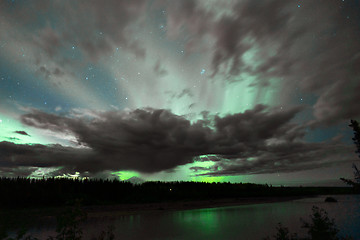 Image showing The Aurora Borealis emerges through clouds remote Alaska