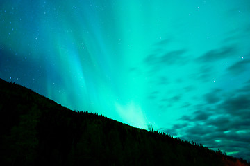 Image showing The Aurora Borealis emerges through clouds remote Alaska