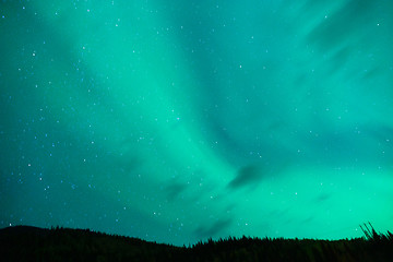 Image showing The Aurora Borealis emerges through clouds remote Alaska