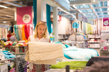 Image showing Woman choosing the right item for her apartment in a modern home furnishings store.