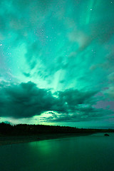 Image showing Lake Reflects Aurora Borealis Emerging Through Clouds Remote Ala