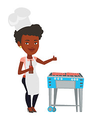 Image showing Woman cooking meat on gas barbecue grill.