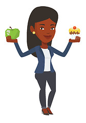 Image showing Woman choosing between apple and cupcake.