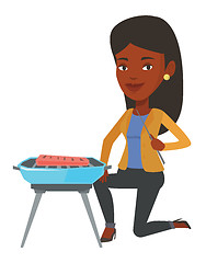 Image showing Woman cooking meat on barbecue.