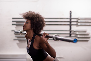 Image showing black woman lifting empty bar