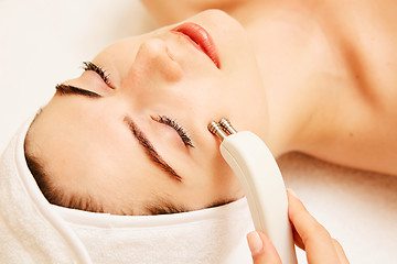 Image showing Cosmetology. Beautiful Woman At Spa Clinic Receiving Stimulating Electric Facial Treatment From Therapist. Closeup Of Young Female Face During Microcurrent Therapy. Beauty Treatment.