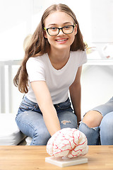 Image showing Schoolgirl watching model of the human brain.