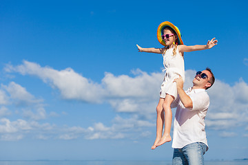 Image showing Father and daughter playing on the beach at the day time.