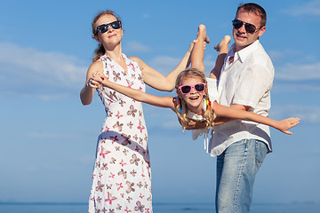 Image showing Happy family walking on the beach at the day time.