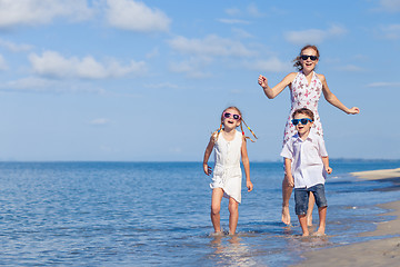 Image showing Mother and children playing on the beach at the day time.