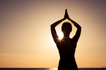 Image showing woman open arms under the sunset at sea.