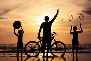 Image showing Father and children playing on the beach at the sunset time.