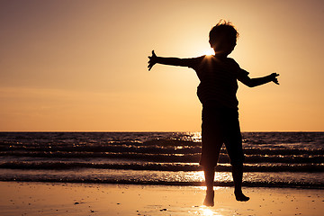 Image showing Happy little boy running on the beach
