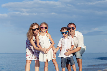 Image showing Happy family walking on the beach at the day time.