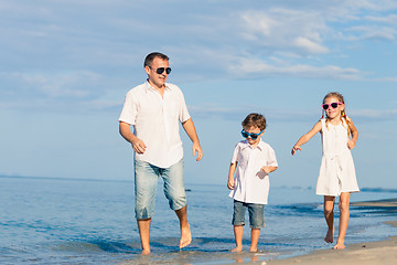 Image showing Father and children playing on the beach at the day time.