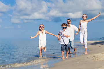 Image showing Father and children playing on the beach at the day time.