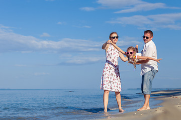 Image showing Happy family walking on the beach at the day time.