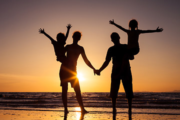 Image showing Silhouette of happy family who playing on the beach at the sunse