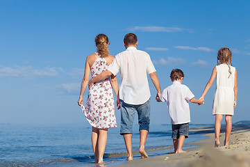 Image showing Happy family walking on the beach at the day time.