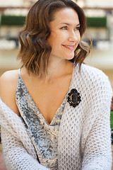 Image showing smiling beautiful woman with a black cameo brooch