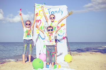 Image showing Two sisters and brother playing on the beach at the day time.