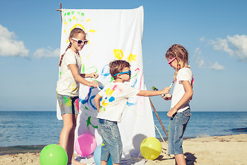 Image showing Two sisters and brother playing on the beach at the day time.