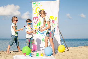 Image showing Two sisters and brother playing on the beach at the day time.