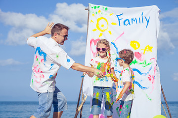 Image showing Father and children playing on the beach at the day time.