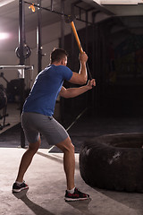 Image showing man workout with hammer and tractor tire