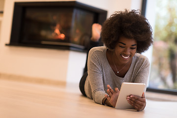 Image showing black women using tablet computer on the floor