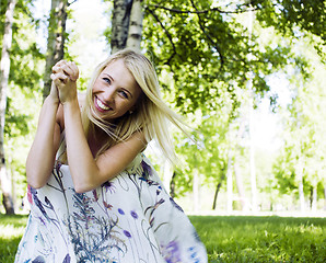 Image showing happy blond young woman in park smiling