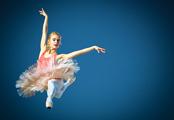 Image showing Beautiful female ballet dancer on a grey background. Ballerina is wearing pink tutu and pointe shoes.