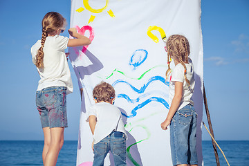 Image showing Two sisters and brother playing on the beach at the day time.