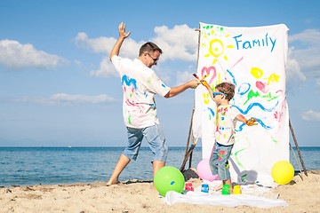 Image showing Father and son playing on the beach at the day time.