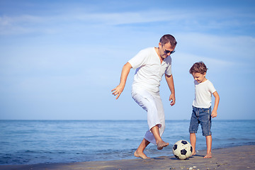 Image showing Father and son playing on the beach at the day time.