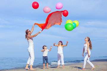 Image showing Mother and children playing on the beach at the day time.