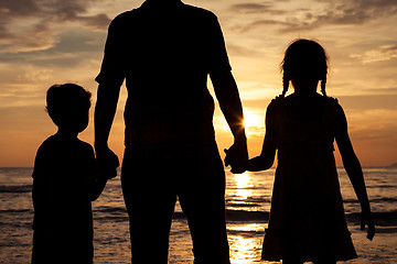 Image showing Father and children playing on the beach at the sunset time.